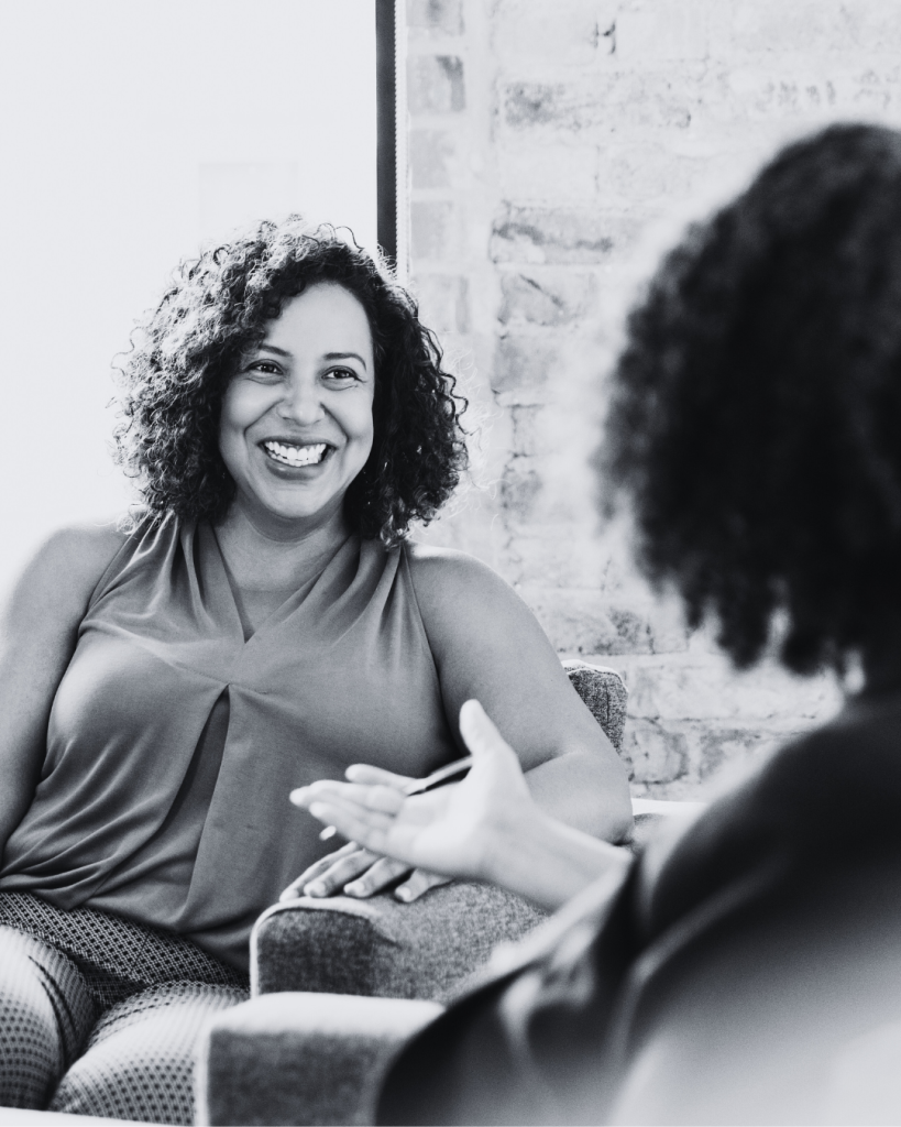 Two women having a conversation, one smiling