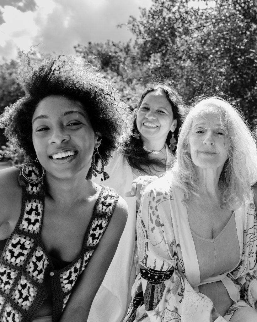 Three women smiling while taking a selfie